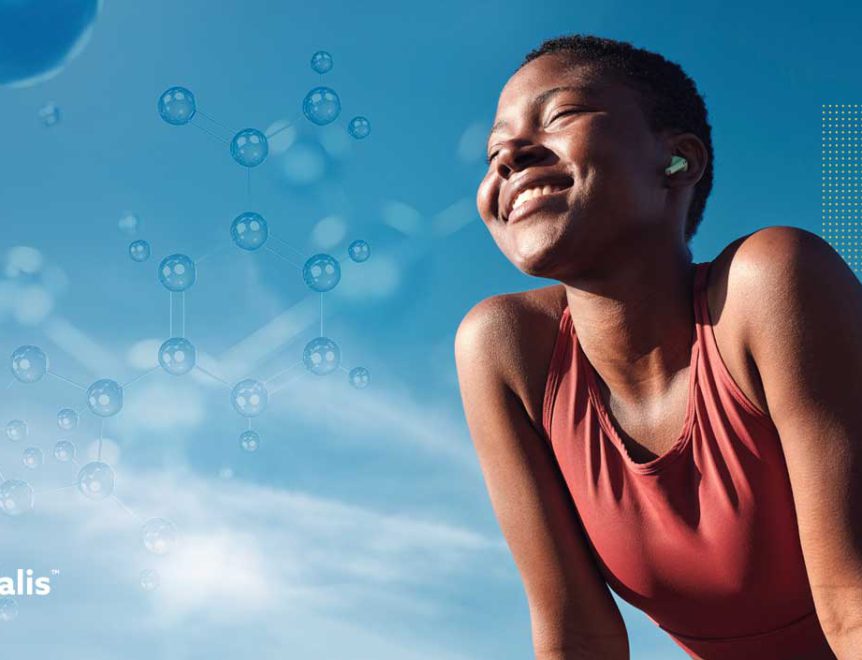 Une femme en bonne santé sourit joyeusement tout en profitant de la vie en plein air, symbolisant ainsi les effets positifs des compléments alimentaires à base de riboside de nicotinamide sur le bien-être.