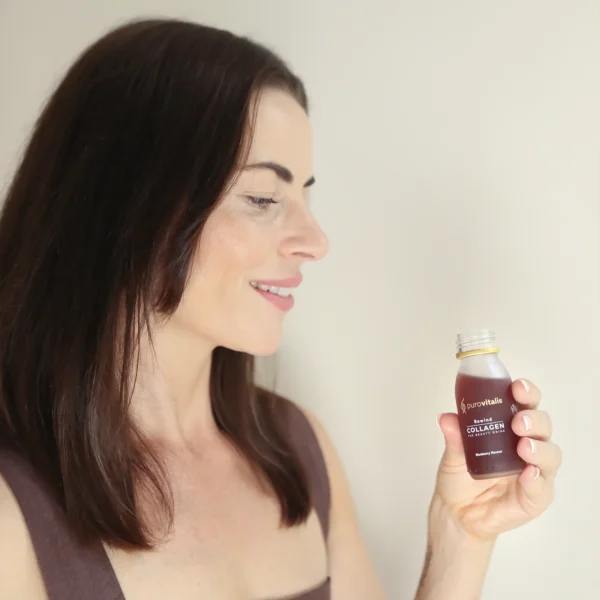 Liquid collagen drink, Rewind by purovitalis including l-ergotheoneine, anthocyanins and more. The photo shows a women holding the purovitalis Beauty drink supplement.