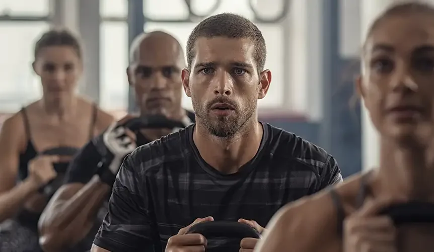 2 mænd og 2 kvinder, der træner med kettlebells, nærbillede