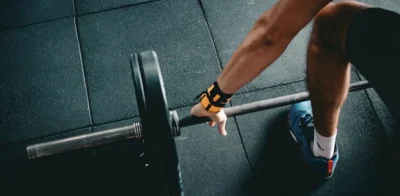 hombre levantando pesas perspectiva de pájaro mostrando sólo un lado del brazo y la pierna