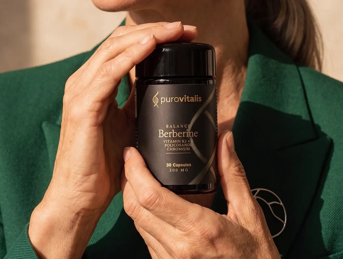 Gros plan sur une femme tenant un flacon du complément alimentaire « Purovitalis Berberine Balance 200 mg », contenant de la vitamine K2, de la vitamine E, du policosanol et du chrome.
