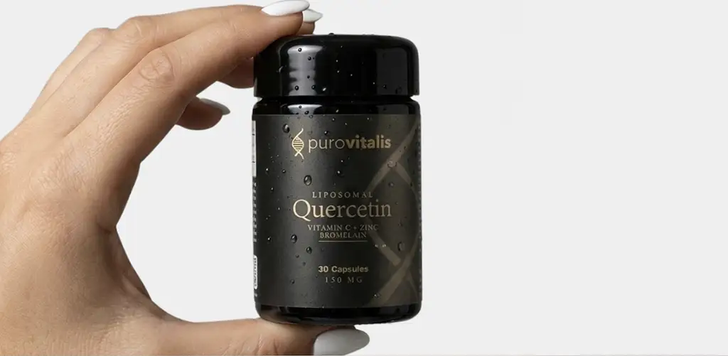 Hand met een black met het label 'Liposomaal quercetine met vitamine C, zink en bromelaïne', met 30 capsules, tegen een lichte achtergrond.