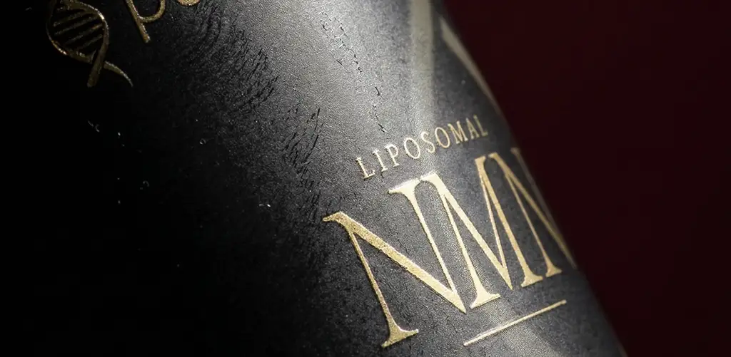 Close-up of a black Purovitalis Liposomal NMN supplement bottle with gold lettering and a dark red background.