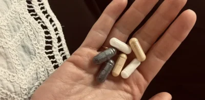 Hand met een selectie supplementen in capsulevorm die de levensduur zouden verlengen.