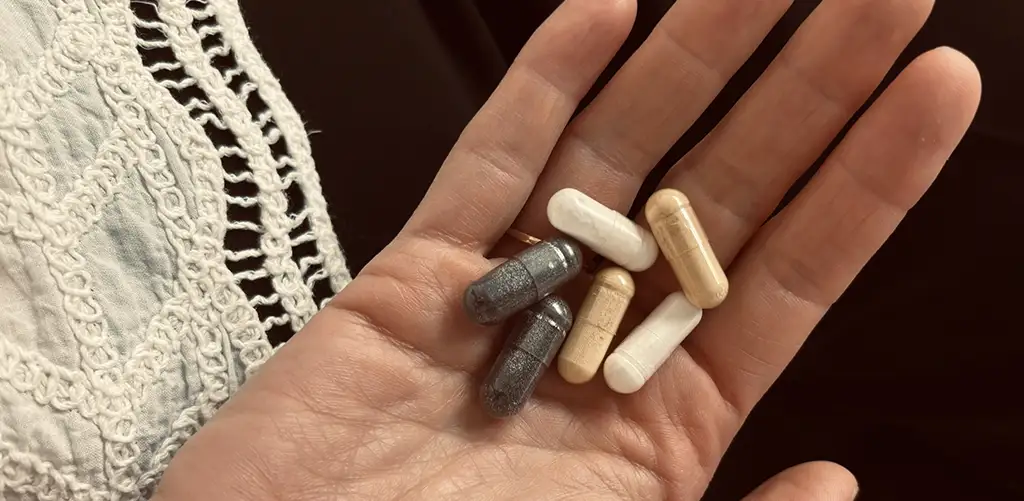 Hand met een selectie supplementen in capsulevorm die de levensduur zouden verlengen.