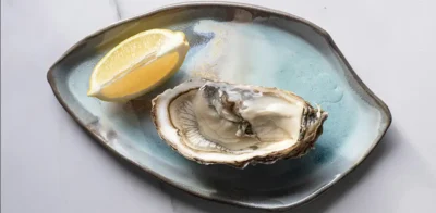 Fresh raw oyster on the half shell with lemon, one of the richest natural food sources of zinc.